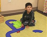 Child playing with cars and track equipment